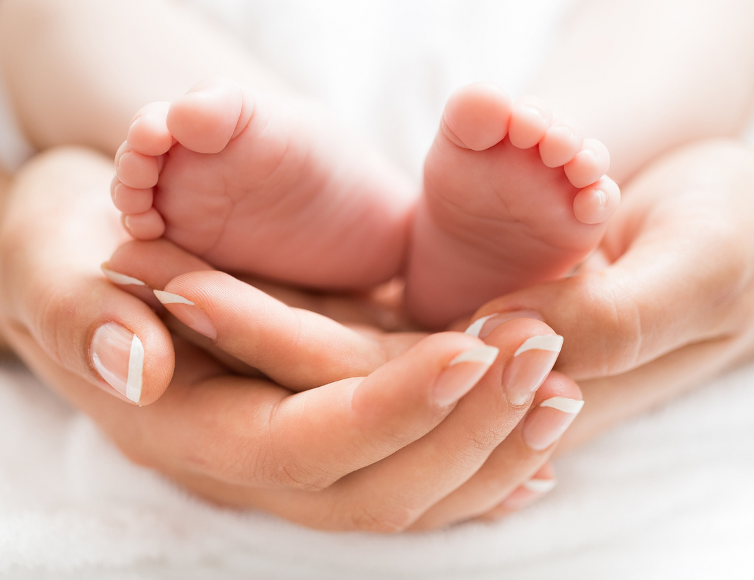 Mother's hands holding tiny baby feet